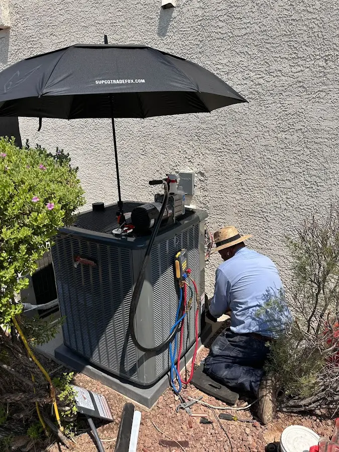 HVAC technician performing outdoor AC maintenance in Gardnerville